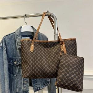 Classic brown monogram tote bag set with matching pouch displayed on a metal stand
