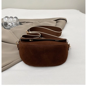 Détail de la sacoche selle en daim café foncé avec bandoulière large en tissu tissé