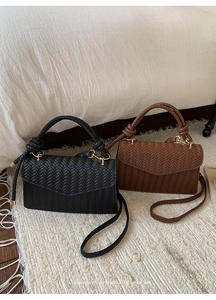 Close-up of minimalist woven texture bags in black and brown with knotted top handles