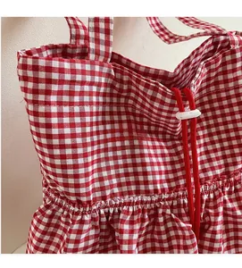 Detail of red gingham canvas tote bag showing drawstring closure and soft fabric texture