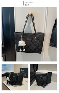 Detail of black quilted canvas tote bag with sequins and cloud plush pendant