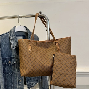 Classic brown monogram large tote bag with matching pouch shown on display stand
