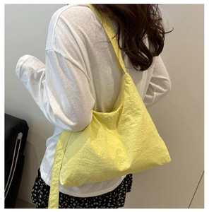 Vue arrière du mannequin portant un grand sac bandoulière en toile jaune vif avec sangle