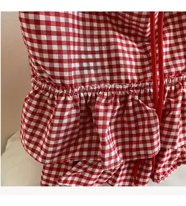 Detail of red gingham fabric with ruffled edges and red drawstring on a tote bag
