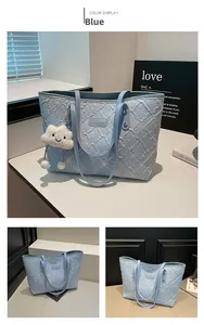 Detail of light blue embroidered tote bag with textured quilting and cloud plush charm