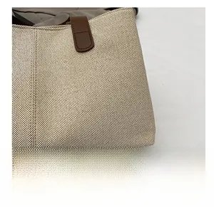 Detailed macro view of linen fabric texture and dark brown leather edge stitching