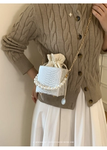 Detailed shot of white snake pattern box bag featuring a large pearl handle and gold chain
