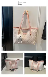 Detail of pink leather handles and woven texture on a large canvas tote bag