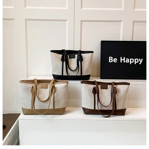 Detailed view of canvas tote bags with contrast leather reinforcement in three colors