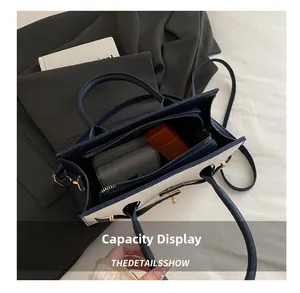 Display della capacità della borsa bicolore con trama litchi e oggetti quotidiani