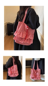 Detail of red and white gingham tote bag featuring aesthetic ruffled layers and long straps