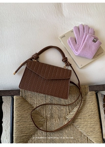 Detail showing deep brown woven texture and stylish knot handle of this square handbag