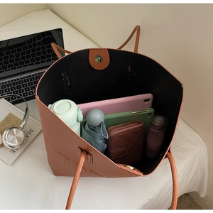 Vista dall'alto dell'interno della grande borsa tote rosso mattone con accessori