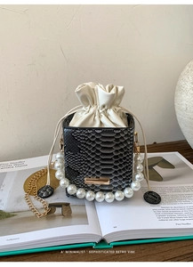 Macro shot of snake pattern box bag featuring pearl handle and drawstring detail