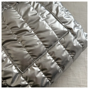 Close-up of silver quilted space cotton tote bag fabric with metallic finish and stitching