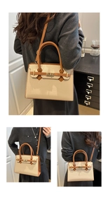 Dettaglio in pelle litchi beige con chiusura girevole dorata e tracolla a contrasto