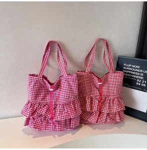Detail of red and pink plaid tote bags with ruffle design and drawstring closure