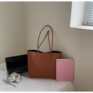 Borsa tote marrone con scritta TOTE BAG presentata con laptop e accessori in scena lifestyle