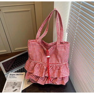 Detail of red gingham canvas tote bag featuring tiered ruffles and drawstring closure