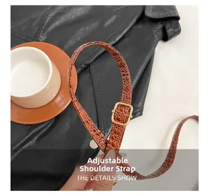 Détail de la bandoulière en cuir marron texturé crocodile avec boucle en métal doré