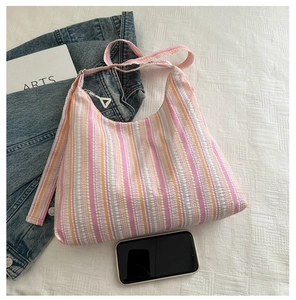 Détail du sac à bandoulière en toile rayée colorée avec tissu texturé et fermeture éclair