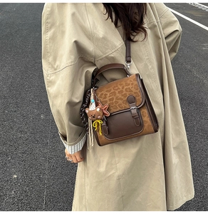 Close-up of brown retro crossbody bag featuring animal print texture and plush bear charm