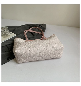 Close-up of quilted tote bag texture with long straps on a minimalist background