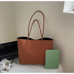 Dettaglio della borsa tote color caramello con scritta in rilievo e capiente interno