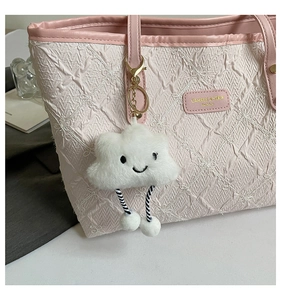 Detail of pink quilted tote bag with star embroidery and white plush cloud charm