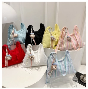 Texture détaillée de sacs fourre-tout en toile gaufrée avec pendentifs de personnages