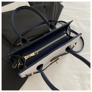 Vista dall'alto della borsa tote bicolore blu navy e bianco crema con zip dorata e interni