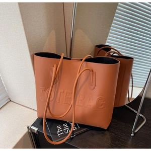 Dettaglio della scritta TOTE BAG in rilievo su una borsa tote vintage in pelle marrone
