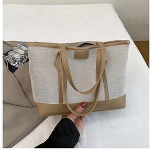 Detail of white mesh tote bag with brown leather trim showing texture and handle