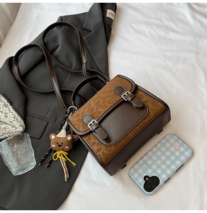 Detailed view of leopard print crossbody bag with plush bear charm on grey blazer
