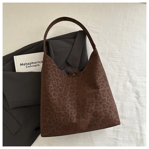 Flat lay of leopard print tote bag with magnetic clasp on neutral background