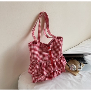 Detail of red gingham tote bag featuring layered ruffles and drawstring closure