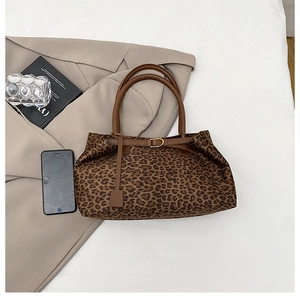 Macro detail of leopard print tote bag with brown straps and golden buckle on a beige blazer