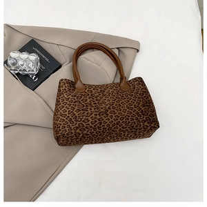Flat lay of leopard print tote bag on a beige blazer with chic lifestyle props