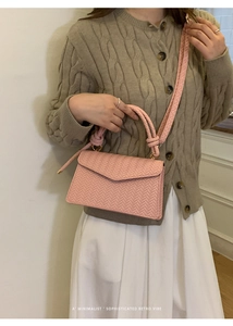 Pink woven texture crossbody bag with flap closure and matching top handle detail