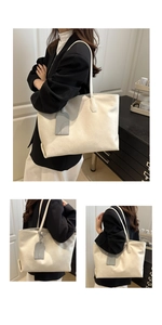 Detail view of cream white textured leather tote bag with elegant strap and charm decoration