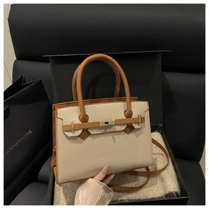 Dettaglio borsa in pelle martellata con chiusura dorata in confezione regalo di lusso