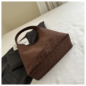 Detail of vintage leopard print hobo bag in brown suede texture for autumn fashion