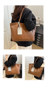 Detail view of large brown faux leather tote bag with stylish contrast off-white charm