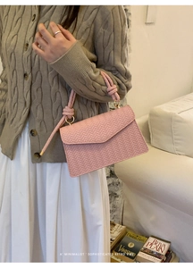 Pink woven texture shoulder bag featuring unique rope knot handle and gold hardware
