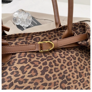 Close-up of leopard print faux fur tote with leather straps and gold D-ring hardware