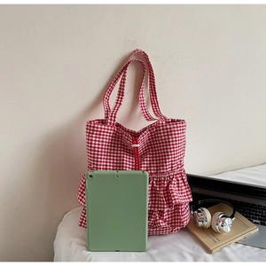 Detail of red and white checkered canvas tote bag with ruffle trim and drawstring closure