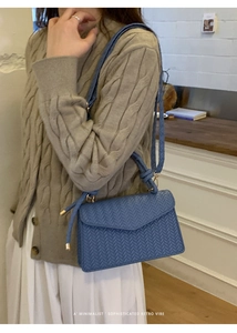 Blue woven faux leather shoulder bag with a textured envelope flap and knotted handle