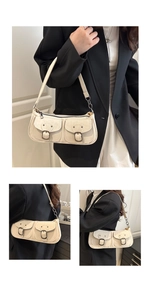 Détail du sac vintage crème avec deux poches à boucle et bandoulière chaîne