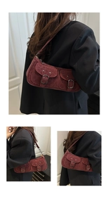 Détail du sac bandoulière bordeaux en daim avec deux poches avant et boucle métallique