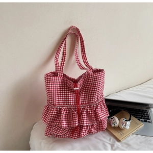 Detail of red gingham canvas tote bag featuring double-layer ruffles and a drawstring closure